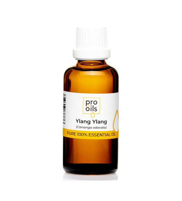 Ylang Ylang essential oil bottle surrounded by fresh ylang ylang flowers, highlighting its aromatic and therapeutic properties