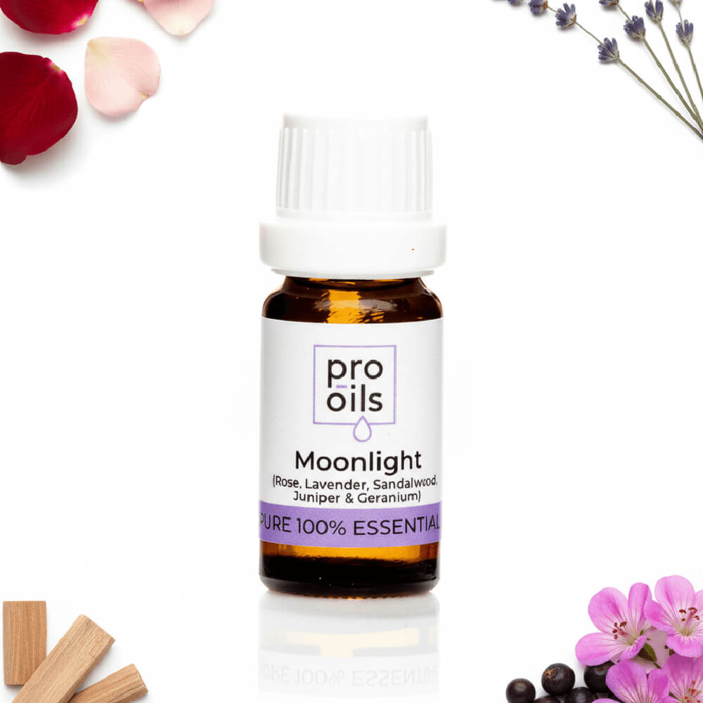Pro Oils Moonlight essential oil bottle with flowers and wooden sticks on a white background