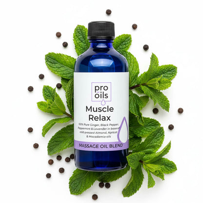 Bottle of Pro Oils Muscle Relax massage oil blend surrounded by mint leaves and peppercorns on a white background