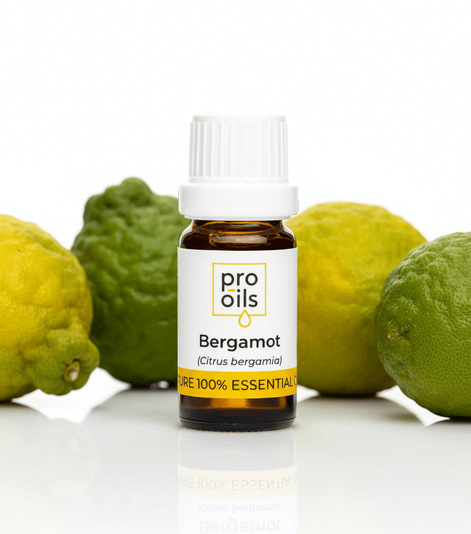 Bottle of Pro Oils Bergamot essential oil with bergamot fruits on a white background