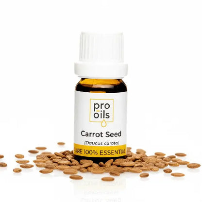 Bottle of Pro Oils Carrot Seed essential oil with seeds on a white background